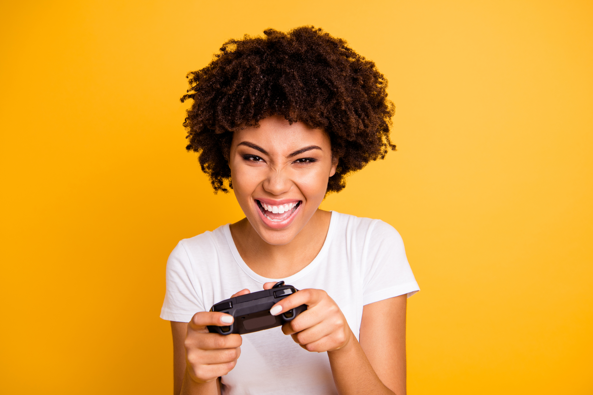 A young woman enjoying a paid video game session over a yellow background.