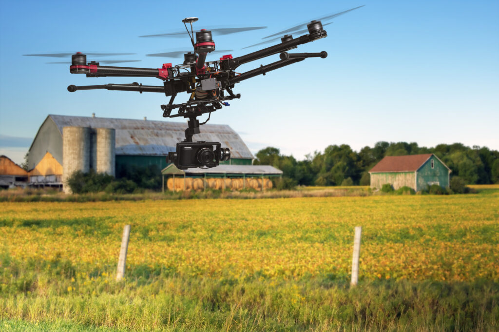 A drone capturing aerial footage of a farm featuring a charming barn in the background.