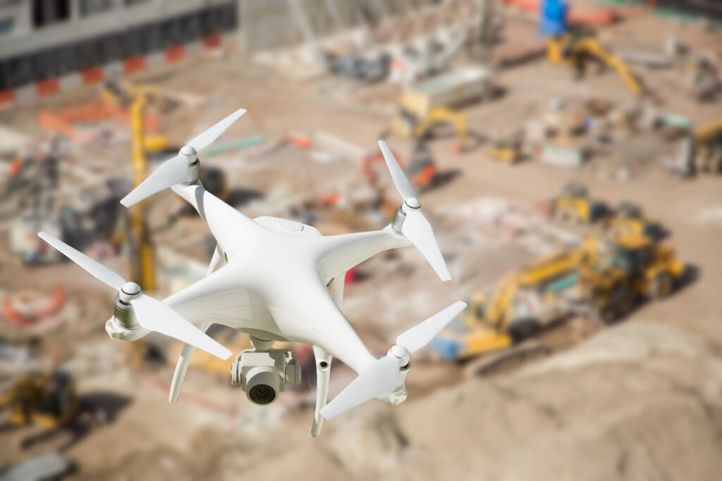 A white drone making money by flying over a construction site.