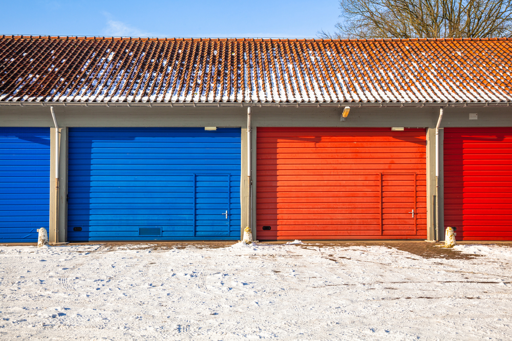 Red and Blue Fire Brigade Garage Doors and Frost roads service next to each other on a Snowy Winter Day