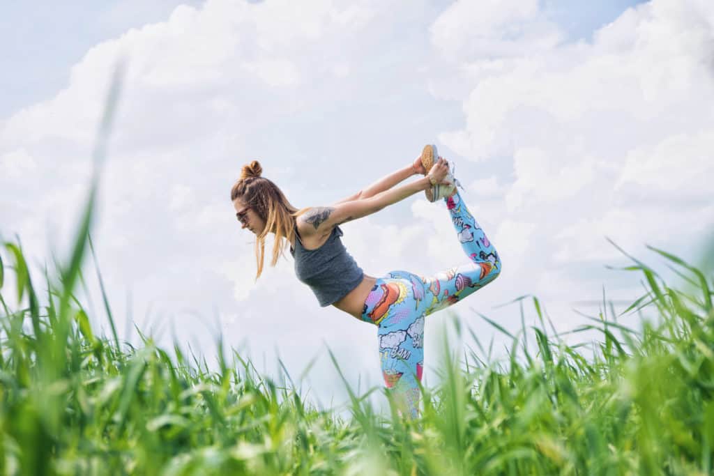 girl doing yoga in a field