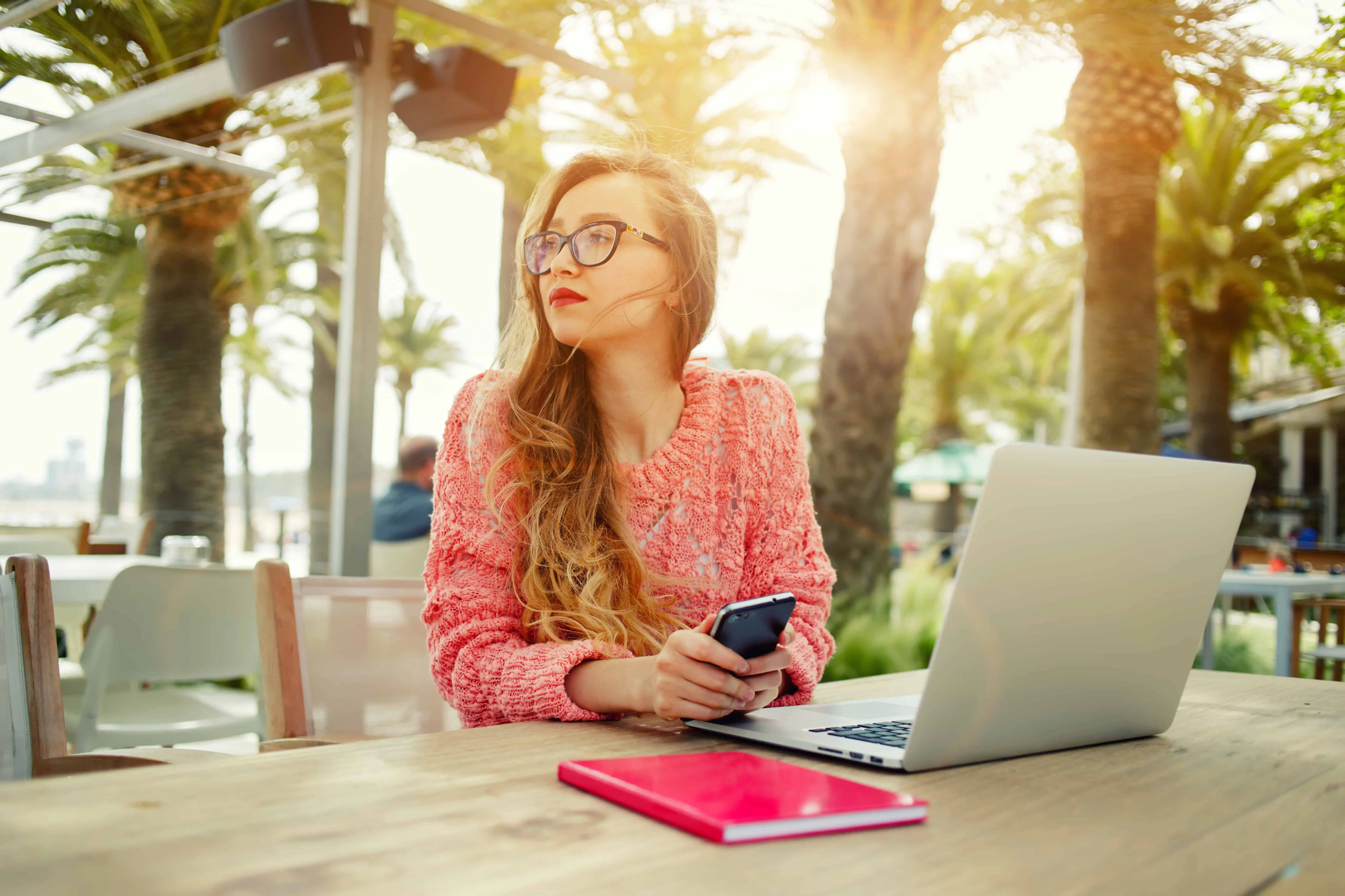 Blogger in pink working outside. Blogging is a fantastic work from home idea and you can start for free!