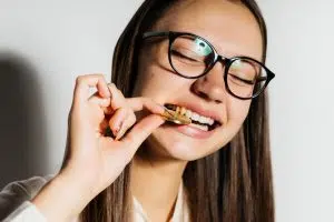 a woman in glasses biting a bitcoin