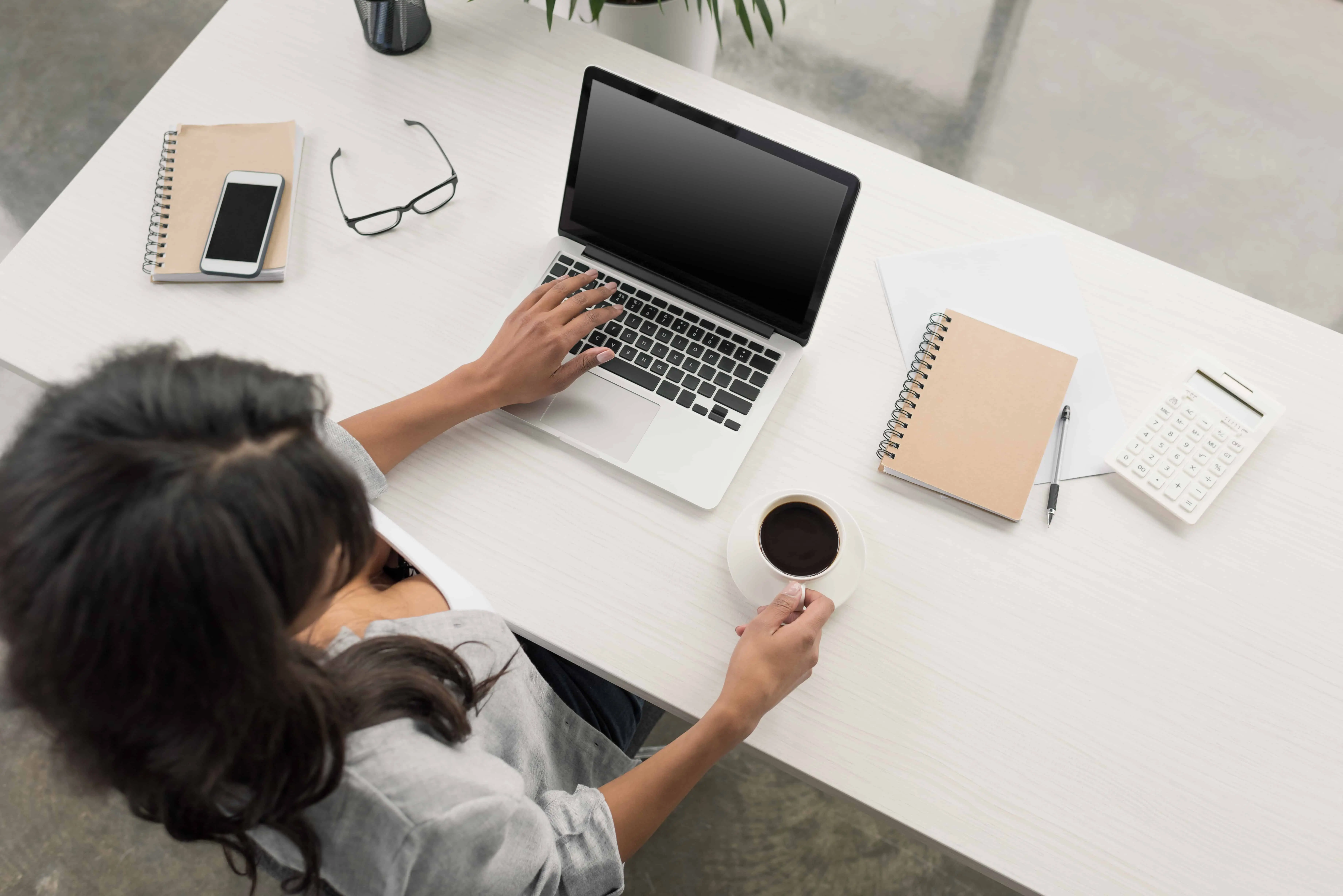 a blogger at her desk with laptop and coffee