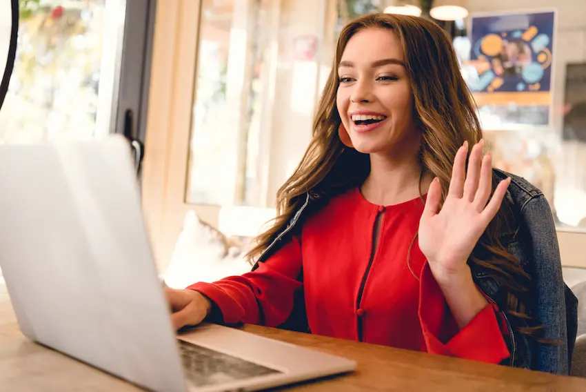 woman waving at the computer