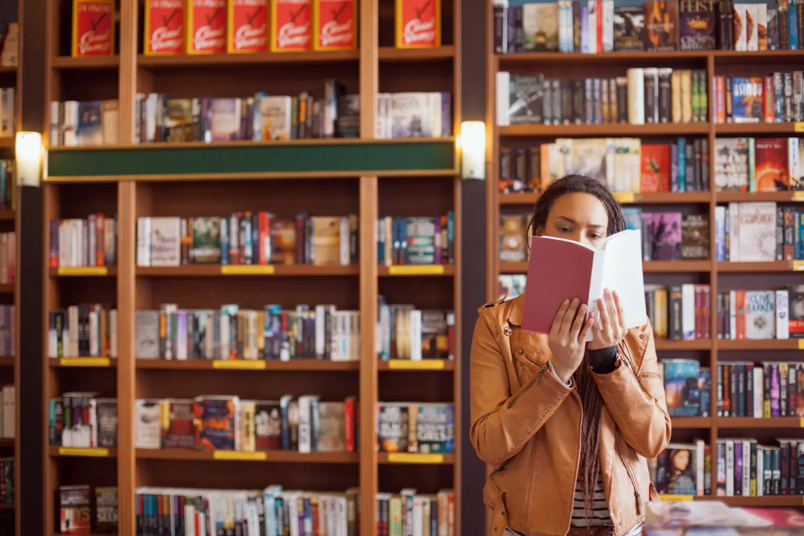 a woman in a book shop, reading a book