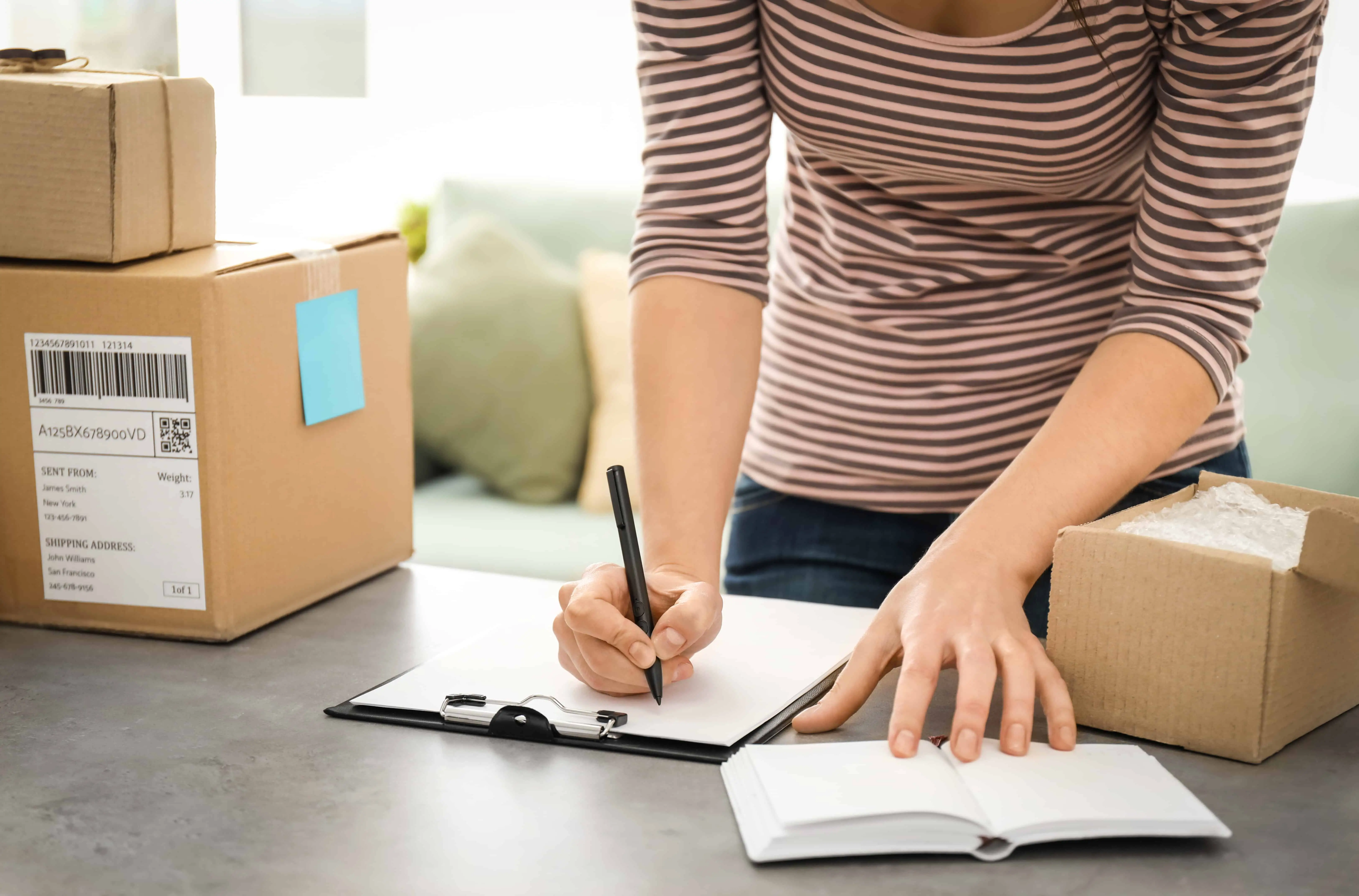 A woman preparing packages in boxes to ship. You could get paid to shop with retail arbitrage.