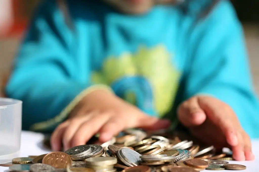 a child counting their pocket money in coins