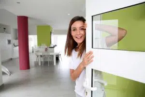 Young woman welcoming people at entrance door of her home