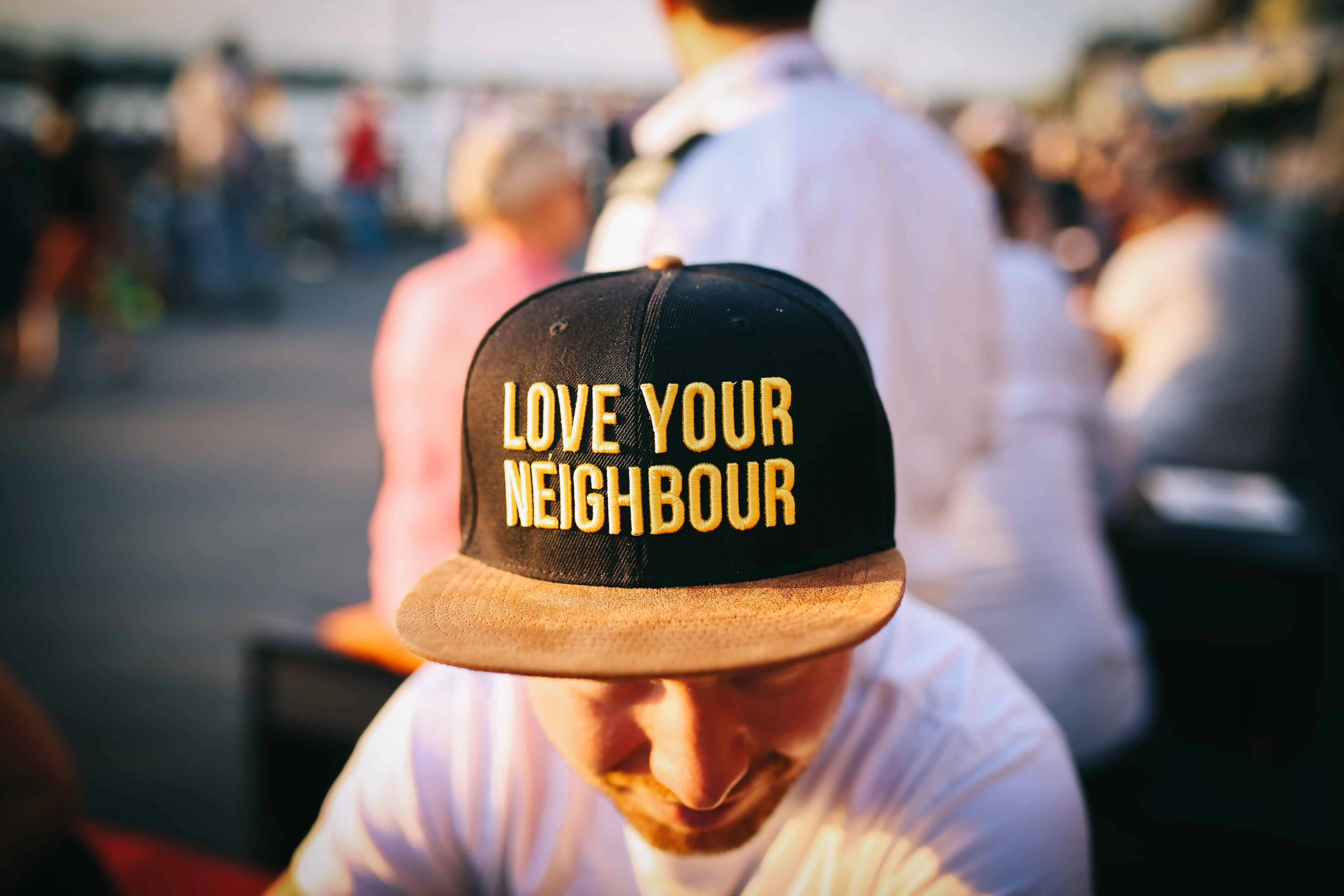 man wearing baseball cap with 'love your neighbour' slogan - another item you could sell with print on demand