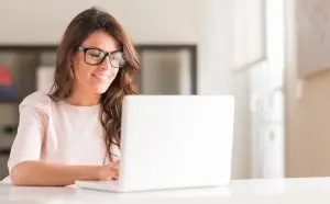 smiling woman doing survey sites on her laptop